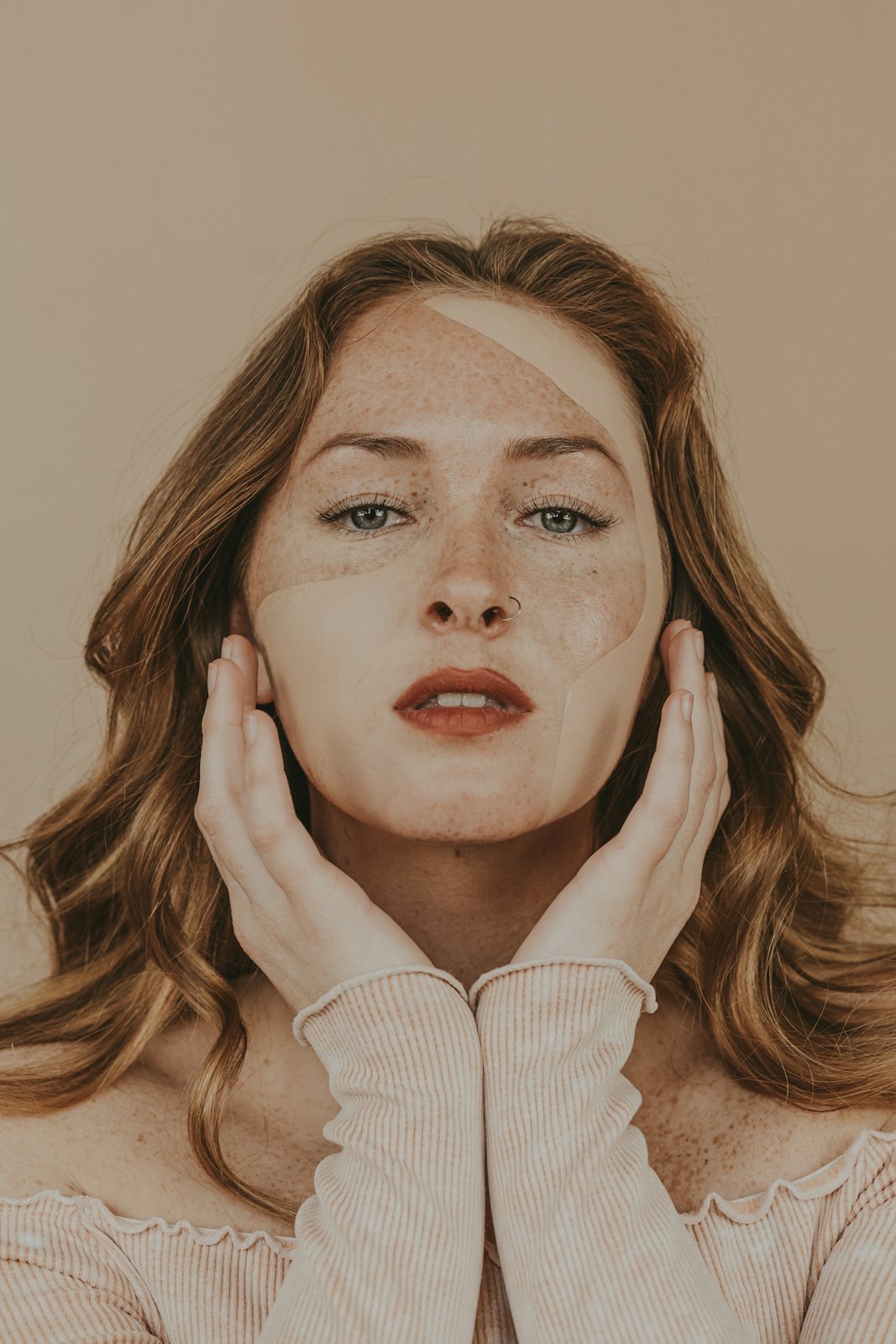 A softly lit portrait of a woman with freckles.
