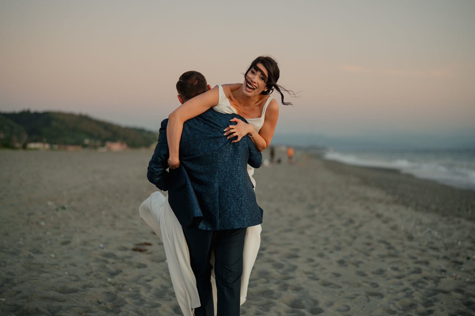 A wedding couple embracing on the beach